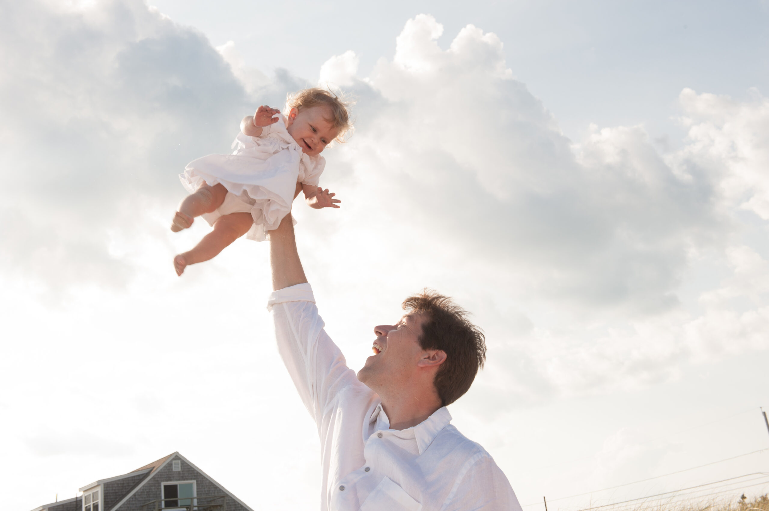 CT family photography father tossing daughter in air joyful beach cottage