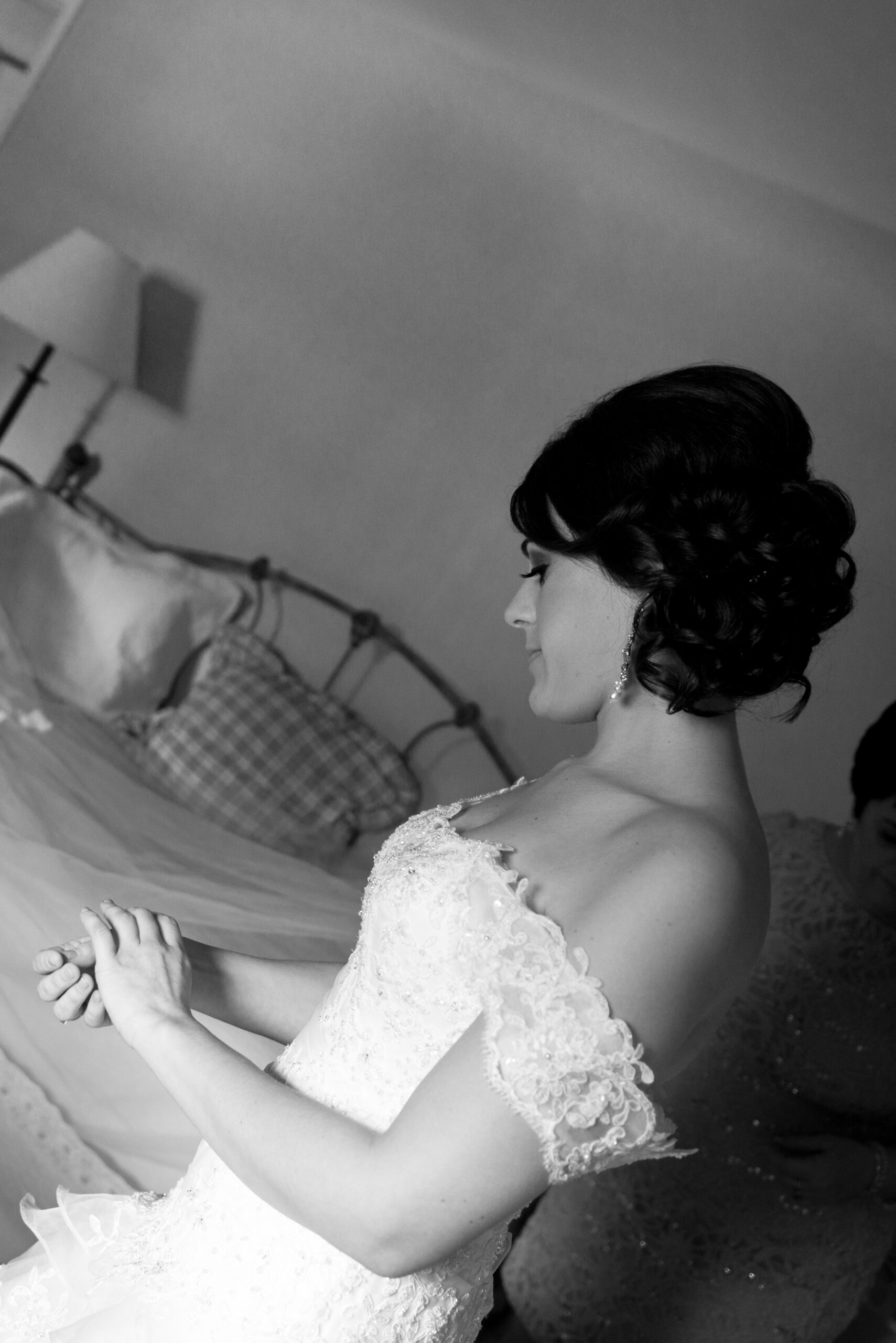 Bride in lace wedding gown sitting quietly while getting ready at the Riverhouse at Goodspeed Station in East Haddam CT
