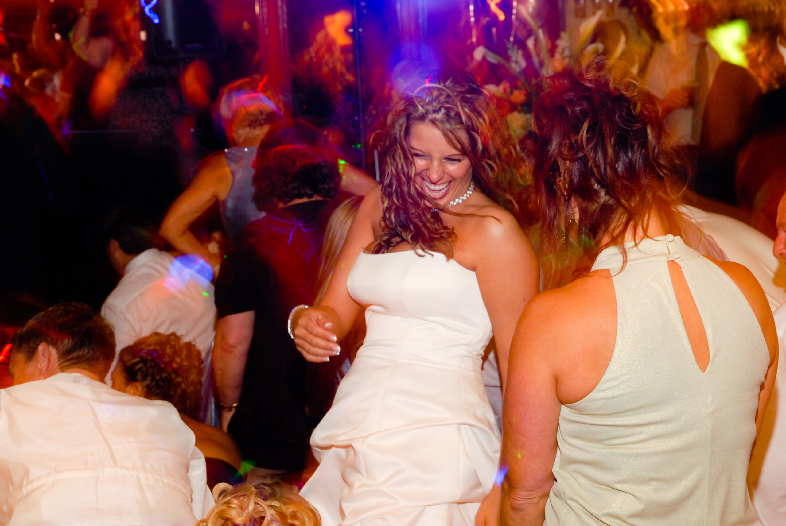 Bride laughing on a packed dance floor surrounded by wedding guests at St. Clements Castle in Portland CT