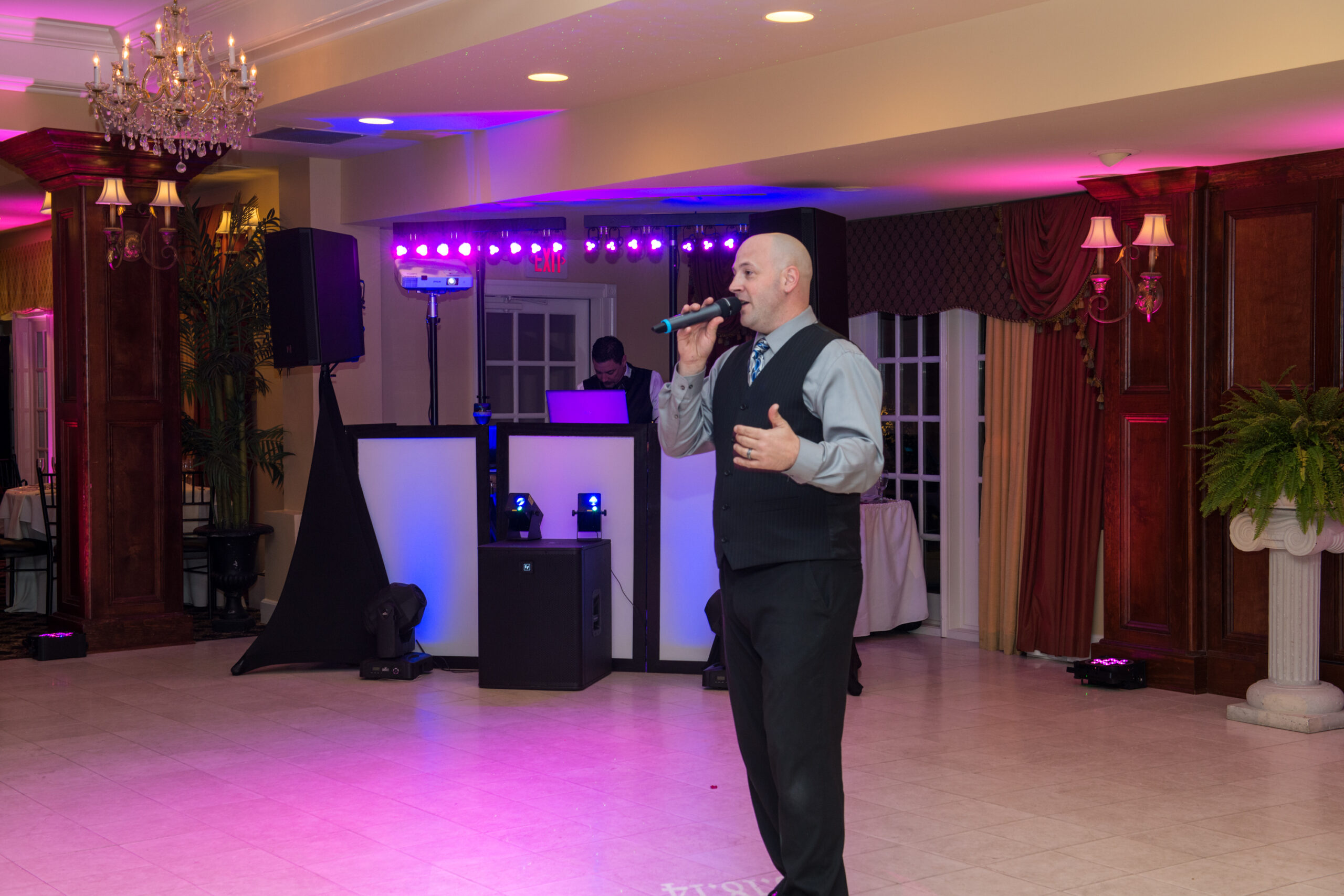 Dave Krevalin as MC in the foreground with the DJ working behind him at the Woodwinds in Branford CT during a wedding reception