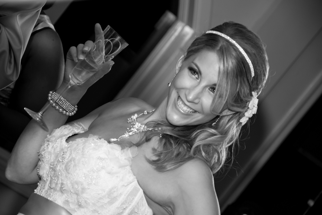 Bride smiling with a champagne glass in black and white at the Candlewood Inn in Brookfield CT