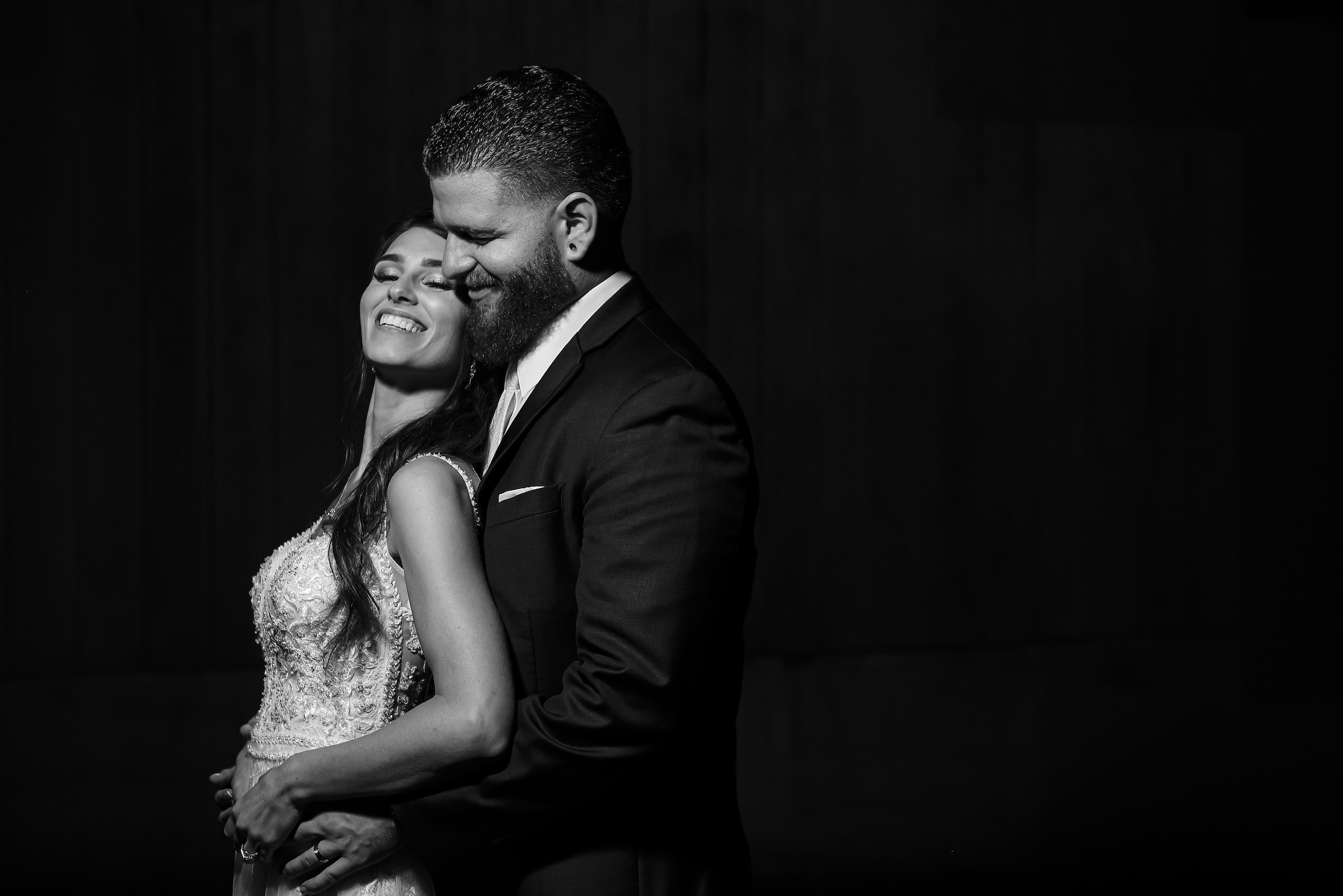 Bride and groom embracing and smiling in a dramatic black and white portrait at Powder Ridge Resort in Middlefield CT